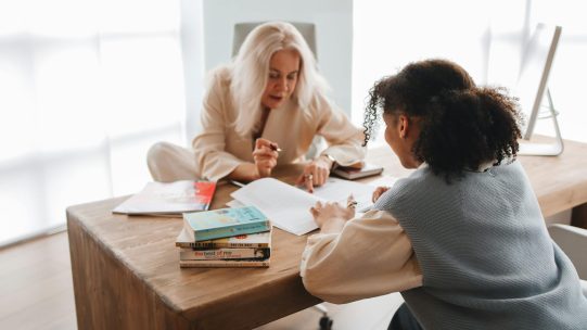 Tutor discussing independent study plan with student and parent at home